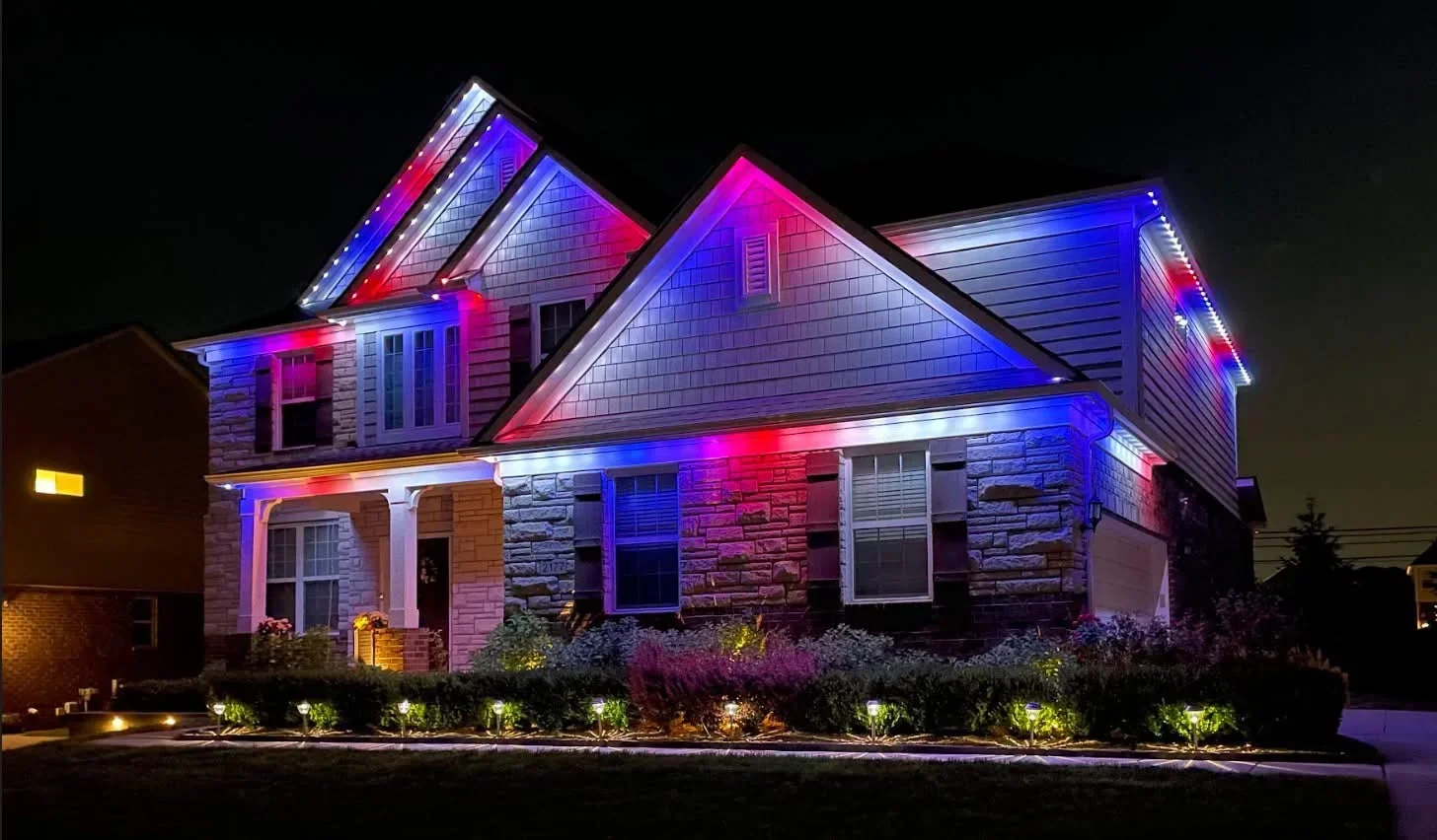 Two-story home with RGB LED accent lighting on rooflines, gables, and architectural trim at night